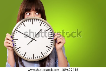 A Young Girl Holding A Clock On Green Background