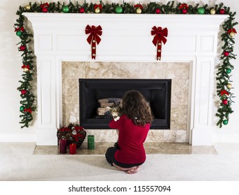 Young Girl Holding Family Cat In Front Of Holiday Decorated Natural Gas Fire Place In Living Room Of Home