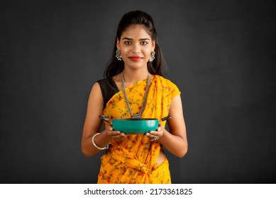 Young girl holding and posing with kitchen utensils pan on a grey background - Powered by Shutterstock