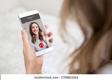 A young girl holds a mobile phone in hand and talking to her girlfriend on video chat, video calls, conference