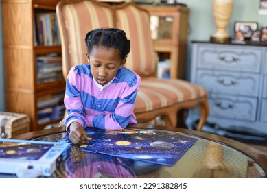 Young girl at home putting together a jigsaw puzzle  - Powered by Shutterstock