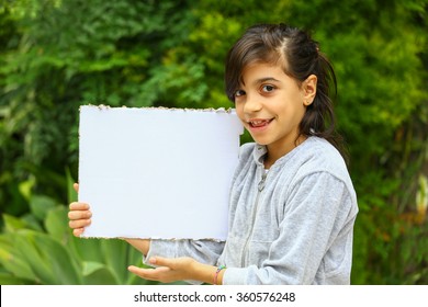 Young Girl With A Hooded Sweatshirt On Outside. Holding A Copy Space Sign.