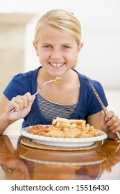 Young Girl Indoors Eating Fish And Chips Smiling