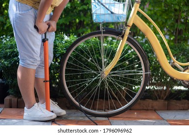   Young girl inflates the bicycle tire - Powered by Shutterstock