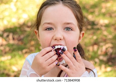 Young Girl Inserting Fake Halloween Fangs