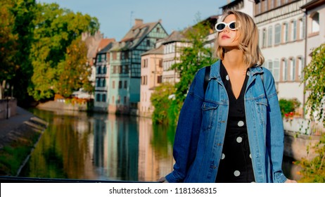 Young Girl In Jeans Jacket And Sunglasses On Street Of Strasbourg, France. Autumn Season Time