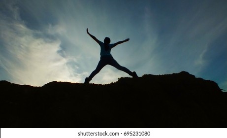 The young girl jump on the mountain background silhouette - Shutterstock ID 695231080