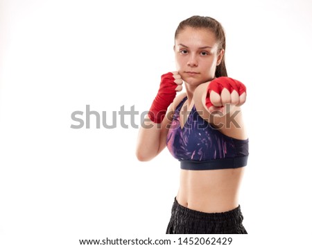 Young girl kickboxing fighter training, isolated on white background