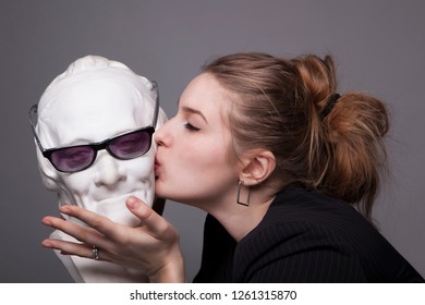 A Young Girl Kisses A Marble Bust Of An Idol