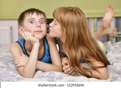 young girl kissing boy on cheek.