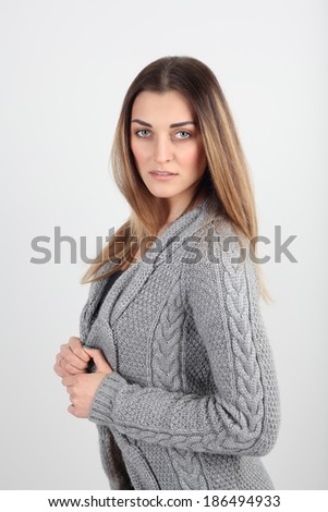 young girl in a knit sweater on a gray background