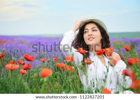 young girl is in the lavender field with red poppy flowers, beautiful summer landscape