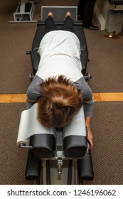 A Young Girl Lays On Her Stomach On A Chiropractic Adjustment Table Waiting For The Chiropractor To Come Work On Her.  