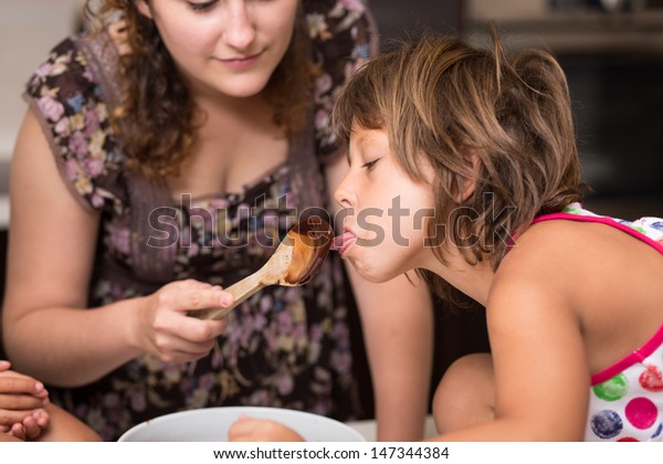 Young Girl Licking Chocolate Off Spoon Stock Photo Edit Now 147344384
