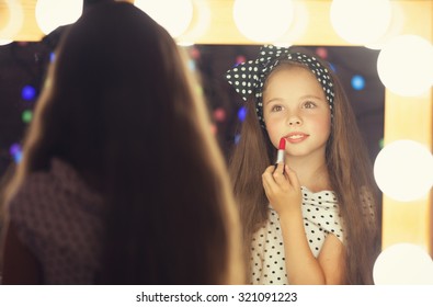 Young Girl With Lipstick Sitting Mear A Mirror.