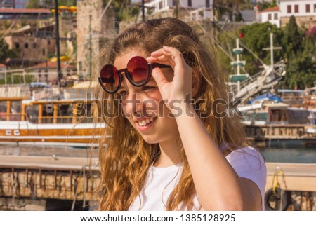 Young girl with long hair on the pier in yacht harbour