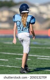 Young Girl With A Long Pony Tail Playing High School Tackle Football