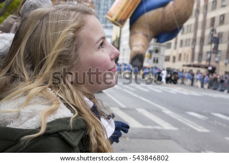 Young girl looking up at Balloons in parade