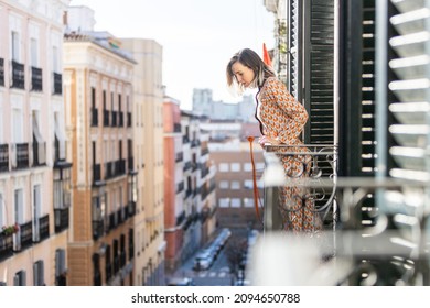 Young Girl Is Looking The City At The Balcony, Looking Down