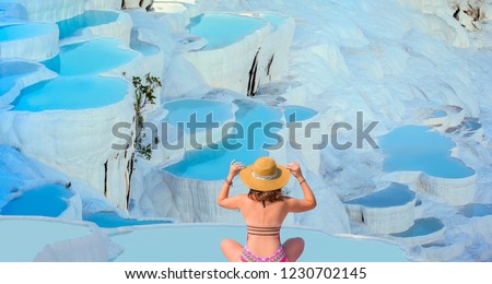 Young girl looking at travertine pools and terraces in Pamukkale -  Young girl sunbathing and sitting front travertine pools - Cotton castle in southwestern Turkey 
