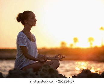 Young Girl In Lotus Pose Outdoors