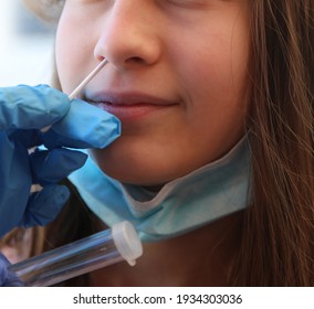 young girl makes a medical swab for coronavirus positivity research and gloves of doctor with test tube for medical analysis