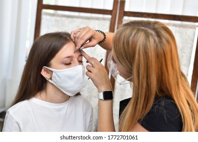 Young Girl And Makeup Artist In Protective Masks, Protective Initiative In A Beauty Salon During The Covid-19 Pandemic.