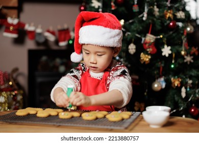 Young Girl Making Gingerbread Man For Celebrating Christmas At Home