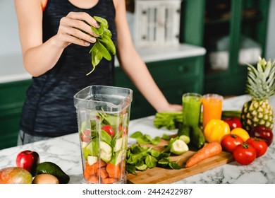 Young girl making green detox cocktail of fresh vegetables and fruits using blender in the kitchen. Healthy eating habits. Diet and vegetarianism for loosing weight and keep body fit - Powered by Shutterstock