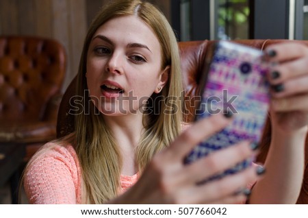 Young girl is making selfie with her colored phone