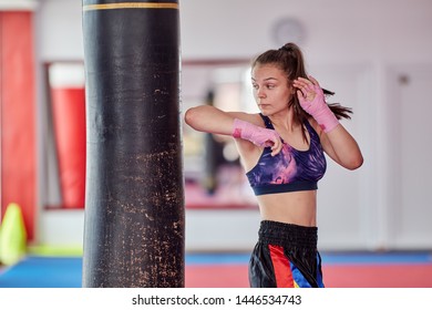 Young Girl Muay Thai Fighter Working With The Heavy Bag