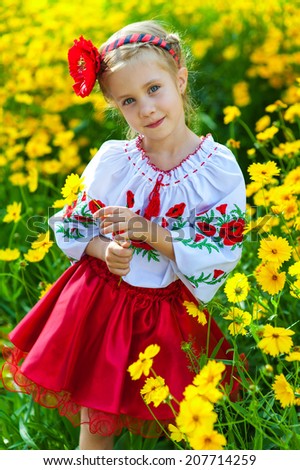 Young girl in national ukrainian clothes on the wheat field. Child outdoor in rural native ukrainian clothes