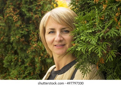 The young girl near green tree branches. Image of a girl clear. The rest is blurry. There are a model release. - Shutterstock ID 497797330