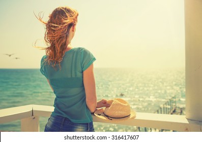 Young girl near the sea. Photo in vintage colored image style.