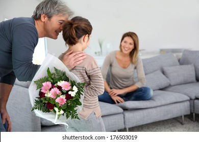 Young Girl Offering Flowers To Her Mom 