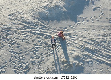 Young Girl In Office Clothes Clasps Her Hands In Prayer And Looks Up . The Second One Is Sitting With Her Head In Her Hands. The Desert Sands. Depression And An Uncertain Business Future , What To Do