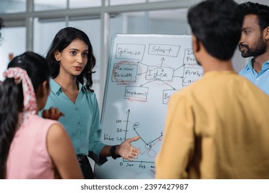 young girl at office discussing about project to team members or colleagues during meeting - concept of leadership presentation, workplace communication and startup culture.