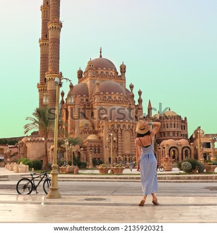 young girl on the background of the El Mustafa Mosque in the Old City of Egypt. Travel to egypt concept. An ancient mosque in the tourist city of Sharm El Sheikh. High quality photo