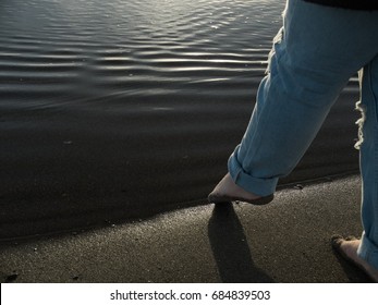 young girl on beach dipping toes in tranquil water, a new opportunity, new life, new chapter