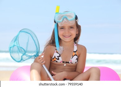 Young girl on the beach with snorkel, mask and fishing net - Powered by Shutterstock