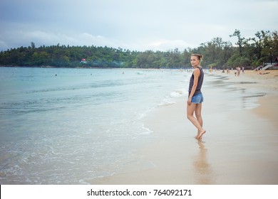 Young girl on blue sea background. Tropical country. Beach waves. Sunset. Dawn. Thailand Phuket Kata