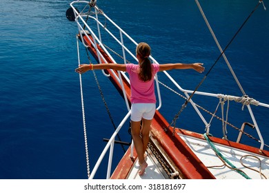 Young Girl On The Bow Of The Boat With Outstretched Arms In An Imaginary Flight