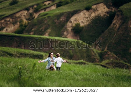 young girl on green grass, mountains, hill