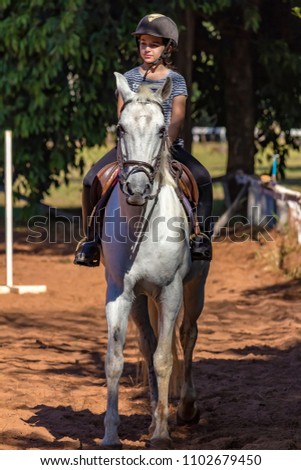 Young Girl on horse in equestrian class - Girl practicing riding class
