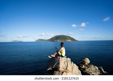 A young girl on a rock and view down in Con Dao island, Vietnam - Shutterstock ID 2181127615