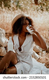 Young  Girl On Safari Nature Drink Milk In Sundress And Hat. Afro Hair, Ecology, Health, Milk Bottle, Brunette, Afro Hair, Relaxation, Tranquility, Farm Products