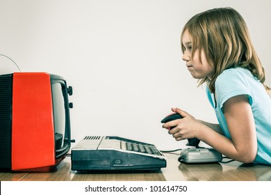 Young Girl On Vintage Video Game Set Up With Joystick Staring Into Red Television Screen