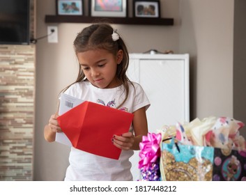 Young girl opening and reading a Birthday Card. - Powered by Shutterstock