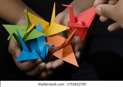 Young Girl With Origami Paper Crane (birds) In Hand Makes A Wish. Inspired By The Japanese Legend That One Who Creates A Thousand Origami Cranes Will Be Granted A Wish.