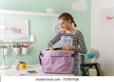 Young Girl Packing Her School Bag 